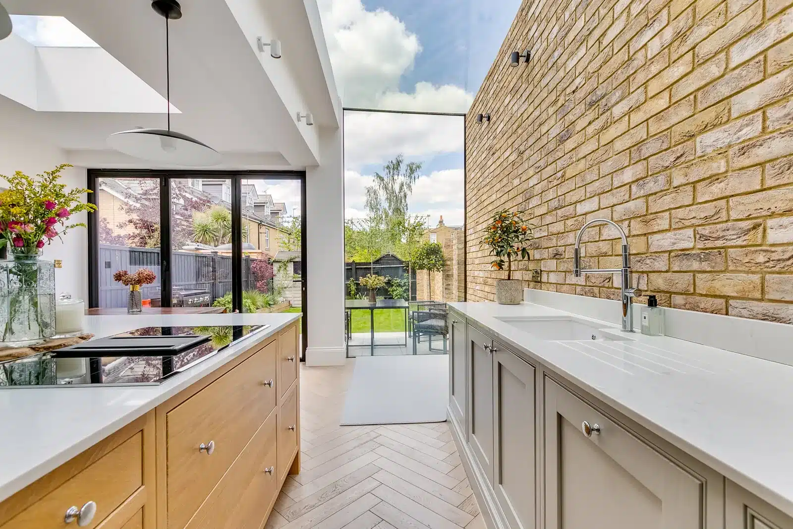 Kitchen with a glazed roof and glass end wall over the side infill, brick flank wall on the right, Earlsfield SW17