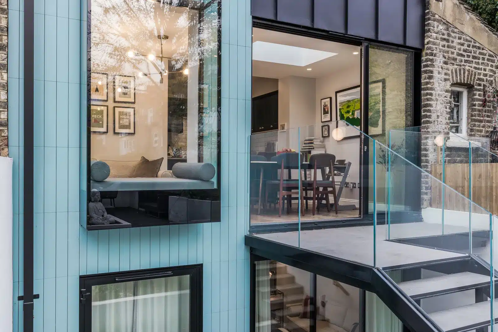 Oriel window seat projecting from the blue vertical-tiled rear elevation of a maisonette extension, Camberwell SE5