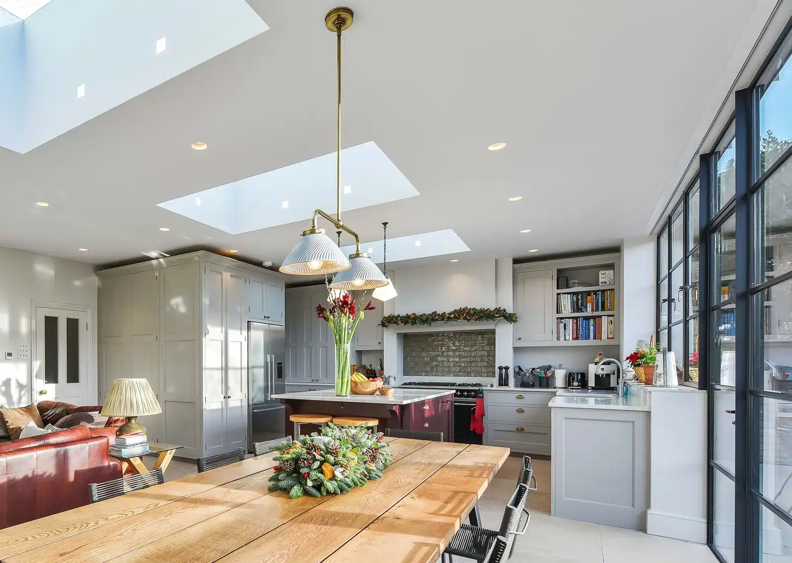 Open-plan kitchen and dining space inside a single-storey rear extension, with three rooflights overhead and Crittall-style glazing to the garden, Wimbledon SW19