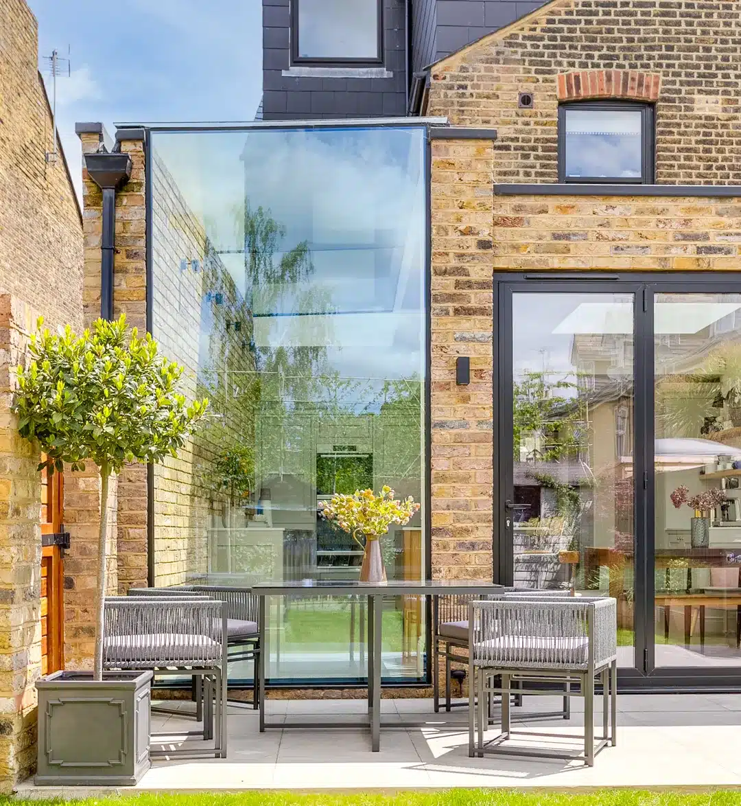 Glass side infill beside a rear extension with sliding doors on a Victorian end terrace, Earlsfield SW17